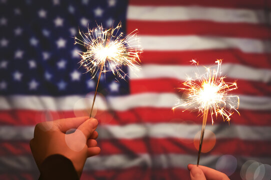 Tips for a Happy, Healthy & Safe Fourth of July - 2 hands holding firework near american flag