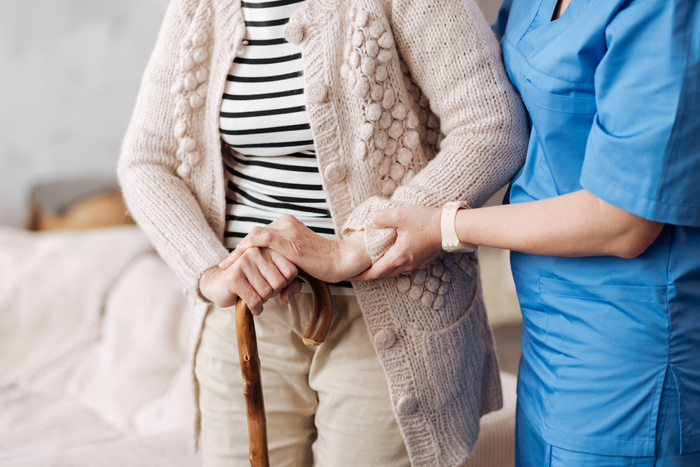 Gentle trained home healthcare nurse helping old patient after surgery