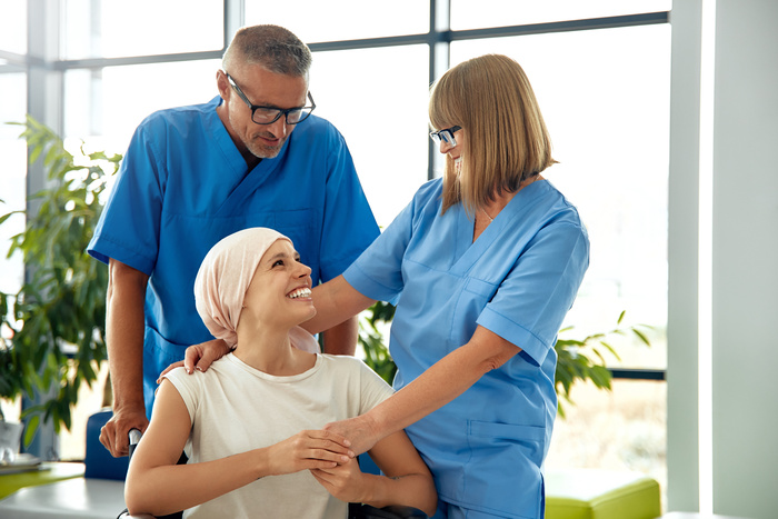 A warm and supportive moment unfolds between dedicated healthcare professionals and a courageous cancer patient, vividly highlighting the significance of compassionate care in the healing process