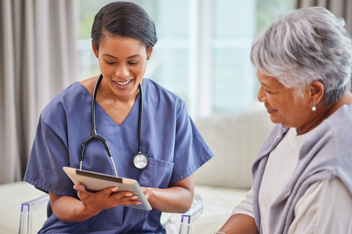 nurse and patient with tablet in elderly care for home assistance